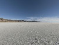 a vast desert with no people or clouds in it, including mountains and blue skies