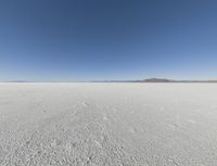 a wide shot of a barren plain in the distance with the sky and mountains in the background