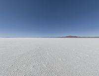 a wide shot of a barren plain in the distance with the sky and mountains in the background