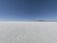 a wide shot of a barren plain in the distance with the sky and mountains in the background