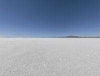 a wide shot of a barren plain in the distance with the sky and mountains in the background