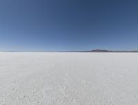 a wide shot of a barren plain in the distance with the sky and mountains in the background