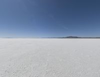 a wide shot of a barren plain in the distance with the sky and mountains in the background