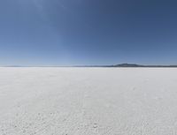 a wide shot of a barren plain in the distance with the sky and mountains in the background