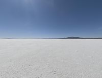 a wide shot of a barren plain in the distance with the sky and mountains in the background