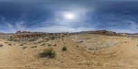 the view from a fish eye lens of a barren plain on a sunny day with a cloudy sky