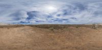 the view from below shows a desert landscape with a half - buried hillside on one side