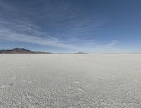 an empty barren plain under some clouds in the blue sky area, looking like something out of a fairy land