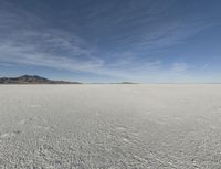 an empty barren plain under some clouds in the blue sky area, looking like something out of a fairy land