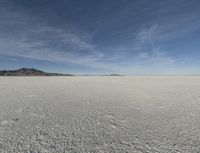 an empty barren plain under some clouds in the blue sky area, looking like something out of a fairy land