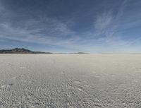 an empty barren plain under some clouds in the blue sky area, looking like something out of a fairy land