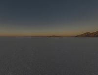 the car is driving through the open plain land at night time in the daytime sun