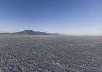 an empty open area, with mountains in the distance as a cameraman zooms by