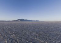 an empty open area, with mountains in the distance as a cameraman zooms by