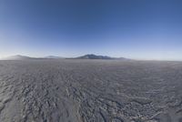 an empty open area, with mountains in the distance as a cameraman zooms by