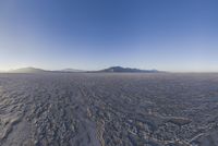 an empty open area, with mountains in the distance as a cameraman zooms by