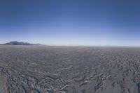 an empty open area, with mountains in the distance as a cameraman zooms by