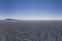an empty open area, with mountains in the distance as a cameraman zooms by