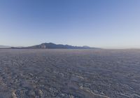 an empty open area, with mountains in the distance as a cameraman zooms by