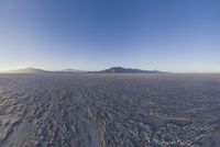 an empty open area, with mountains in the distance as a cameraman zooms by