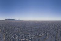 an empty open area, with mountains in the distance as a cameraman zooms by