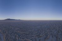 an empty open area, with mountains in the distance as a cameraman zooms by