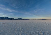 the ground with snow, mountains and a large sky in the background while viewed by a 3d person