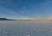 the ground with snow, mountains and a large sky in the background while viewed by a 3d person