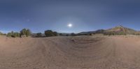 a panoramic image of the desert with the sun in the distance behind it