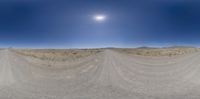 an arid desert scene with road and sky in the background with very no clouds at all