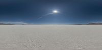 a group of four sun haloes in a desert landscape, over snow - capped mountains