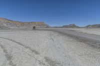 a red truck is driving through the rocky landscape of the desert of an arid area