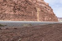 a person on a motorcycle near a rocky mountain and riverbeds in the desert