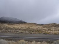 there is an empty highway through the desert mountains and mist, but it does have many different colors