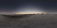 the sun is setting behind some mountains and snow covered fields in the desert with a dirt road