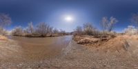 a river and a clear blue sky in a panoramic view of the desert