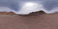 a man walks past a red cliff in the desert during the daytime, as the sun shines over rock formations