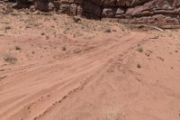 a dirt road in the desert with many rocks on a hillside near the shore of a canyon