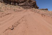 a dirt road leading up to rocks on the edge of a cliff that appears to be very dry