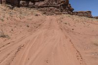 a dirt road leading up to rocks on the edge of a cliff that appears to be very dry