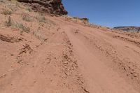 a dirt road leading up to rocks on the edge of a cliff that appears to be very dry