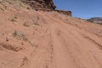 a dirt road leading up to rocks on the edge of a cliff that appears to be very dry