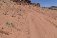 a dirt road leading up to rocks on the edge of a cliff that appears to be very dry