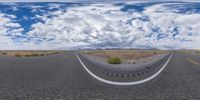 a fisheye lens view shows a desert road in a circle with a mountain in the distance