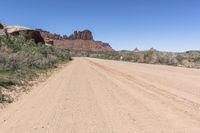 the dirt road is dirty as it goes through the desert in the daytime time with blue sky