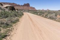 the dirt road is dirty as it goes through the desert in the daytime time with blue sky