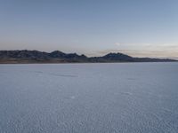 the desert with snow in it and mountains in the distance on the far shore in the foreground