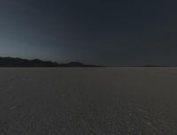 a lone white car traveling on the desert surface during sunset time in the daytime time