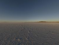 a desert landscape at sunset with an airplane in the sky, on the horizon are mountains and small snow flakes