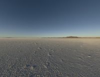 a desert landscape at sunset with an airplane in the sky, on the horizon are mountains and small snow flakes